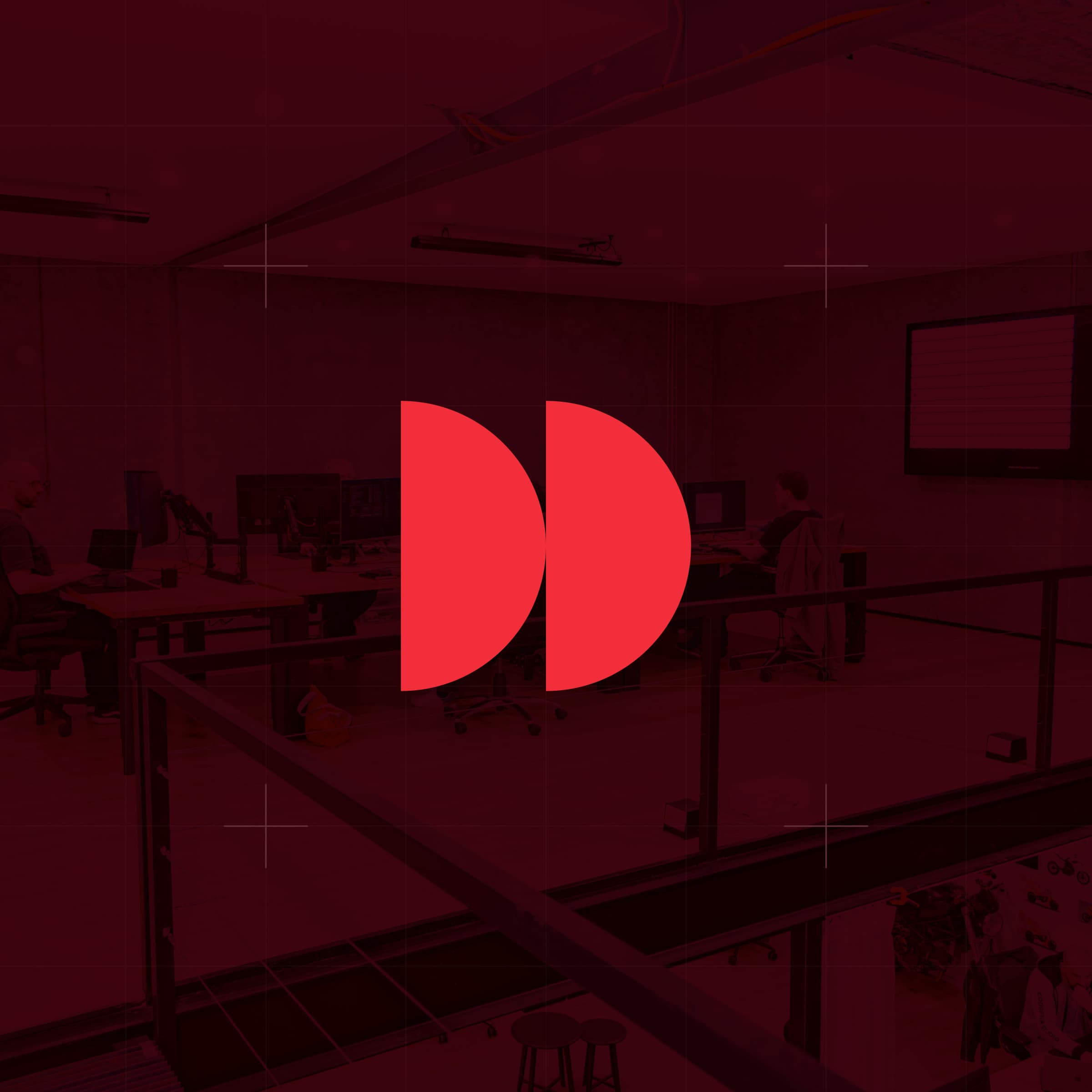 CodeFish Studio twin half-disc glyph over a red-tinted photo of the studio work floor