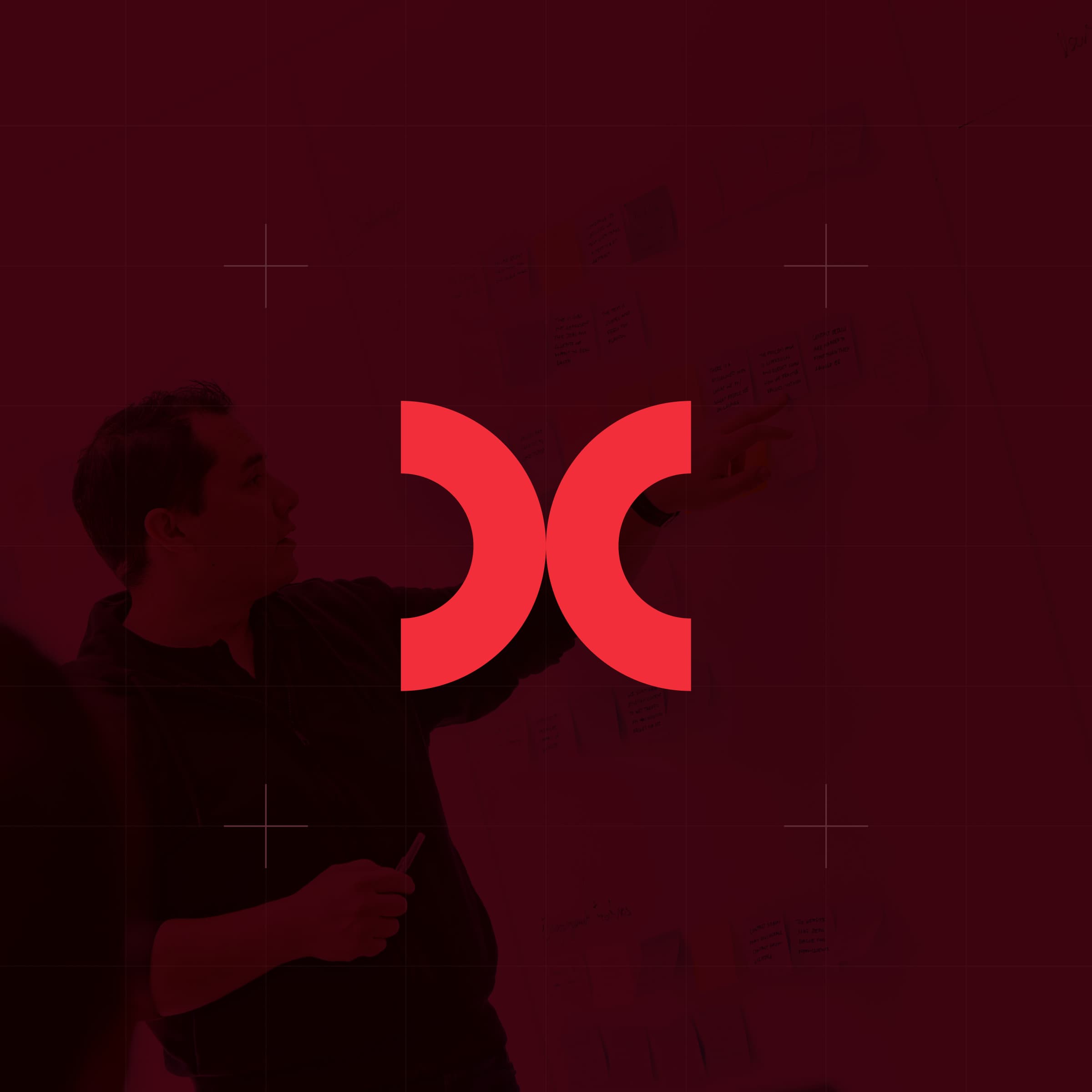 CodeFish Studio double-crescent glyph over a red-tinted photo of a workshop wall session