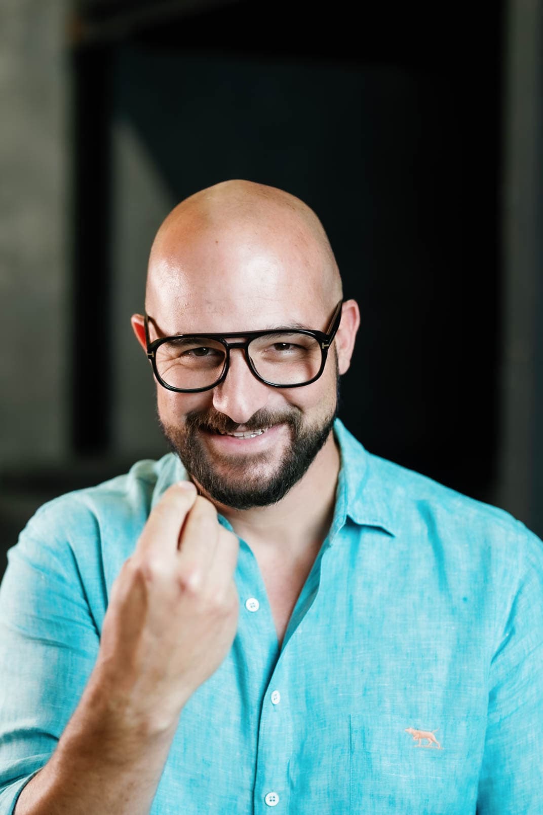 A person in a bright shirt smiling to camera in a studio portrait